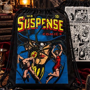 May include: A black drawstring backpack featuring a vintage comic book cover graphic titled Suspense Comics No. 8. The design displays a large spider, a person in a red dress, and a person in red shorts against a blue background. The back shows a black and white comic strip panel.