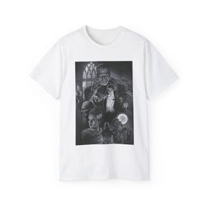 Może przedstawiać: Biały t-shirt z krótkim rękawem z czarno-białym nadrukiem graficznym przedstawiającym klasyczne postacie z horrorów, w tym potwora Frankensteina, Drakulę, Mumię i narzeczoną Frankensteina na tle gotyckiego zamku.
