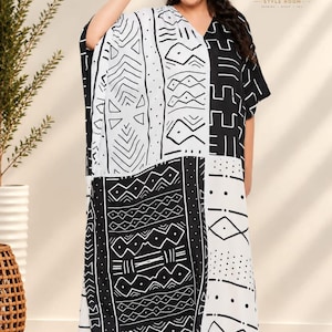 Könnte beinhalten: Ein locker sitzendes Kaftan-Kleid mit einem kontrastreichen schwarz-weißen geometrischen Muster und verschiedenen tribal-inspirierten Motiven. Das Kleidungsstück hat kurze Ärmel, einen V-Ausschnitt und eine lange, fließende Silhouette. Das Logo Modern Style Room ist sichtbar.
