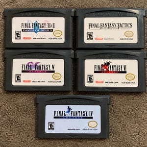 May include: Five grey Game Boy Advance video game cartridges featuring Final Fantasy titles: I & II Dawn of Souls, Tactics Advance, V Advance, VI Advance, and IV Advance. Each cartridge has a white label with black text, the ESRB E rating, and Nintendo logo.