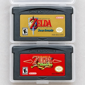 Peut inclure: Deux cartouches Game Boy Advance noires dans des boîtiers en plastique transparent. La cartouche supérieure a une étiquette dorée pour The Legend of Zelda: A Link to the Past & Four Swords. L'inférieure a une étiquette rouge pour The Minish Cap.