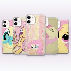 Può includere: Una collezione di cinque cover trasparenti per smartphone con varie illustrazioni grafiche di un personaggio pony giallo con criniera rosa, occhi azzurri e motivi a farfalla, su sfondi pastello tenui con motivi floreali e ad acquerello.