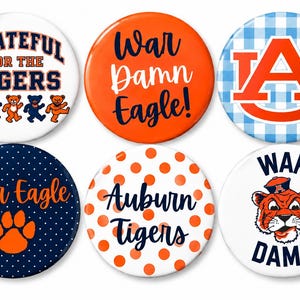 May include: A set of six circular pin-back buttons featuring Auburn University themes. Designs include dancing bears with text Grateful for the Tigers, orange with War Damn Eagle, a blue gingham AU logo, navy polka dots with War Eagle, orange polka dots, and a tiger.