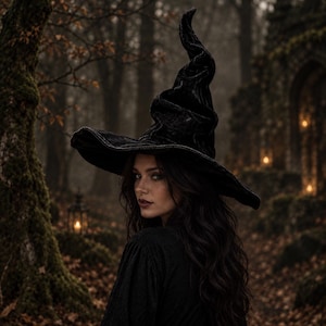 May include: A tall, pointed black velvet hat with a wide, slightly drooping brim. The fabric has a textured, crushed appearance, creating deep folds and shadows along the crown and the curved, flexible brim of this headwear accessory.
