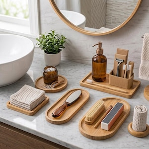 Può includere: Un set di accessori da bagno in bambù composto da diversi vassoi ovali e rettangolari, un dispenser di sapone in vetro ambrato, un vasetto con cucchiaio in legno, una spazzola per capelli, un buffer per unghie, una spazzola per unghie e asciugamani.