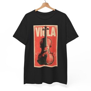 May include: A black short-sleeved t-shirt featuring a rectangular graphic print on the chest. The print displays a red background with a distressed texture, a brown viola illustration, and the word VIOLA in large, bold, off-white capital letters.