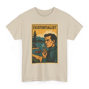 Puede incluir: Una camiseta beige con un estampado gráfico de una persona con cuello de cisne azul oscuro fumando un cigarrillo. El fondo muestra un lago, un pino y una canoa roja bajo un cielo amarillo. El texto "EXISTENTIALIST" está impreso en negro arriba.