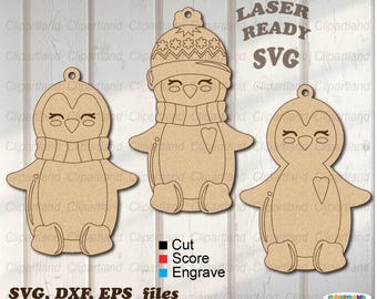 May include: Three laser cut wooden penguin ornaments. The penguins are wearing scarves and hats. The ornaments are ready to be painted or stained. The text "LASER READY SVG" is visible in the image.