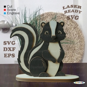 May include: A wooden skunk figurine with black and white markings, standing on a light-colored base. The image includes text that says "Cut, Score, Engrave", "SVG, DXF, EPS", and "LASER READY SVG".