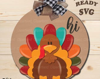 May include: A round wooden sign with a turkey design. The turkey is brown with a red wattle and a yellow beak. The turkey's feathers are red, orange, yellow, green, and blue. The sign says "hi" in black lettering.