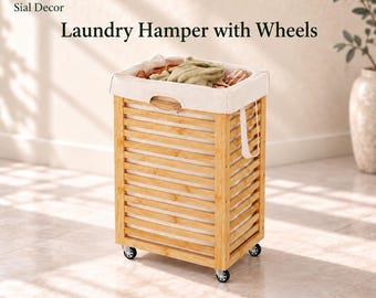 May include: A rectangular laundry hamper with a slatted light brown bamboo frame and a removable cream-colored fabric liner. The unit features four small swivel wheels at the base and two side handles. Text reads Sial Decor Laundry Hamper with Wheels.
