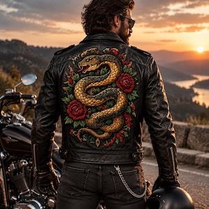 May include: A black leather jacket featuring a large, detailed embroidery on the back. The design depicts a coiled, golden-brown snake surrounded by vibrant red roses and green leaves. The jacket has long sleeves with silver-toned metal zippers.