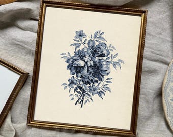 May include: A rectangular gold-toned frame containing a cream-colored print of a dark blue floral bouquet. The print features detailed botanical illustrations of various flowers and leaves. The text *Frames and matting not included is visible.
