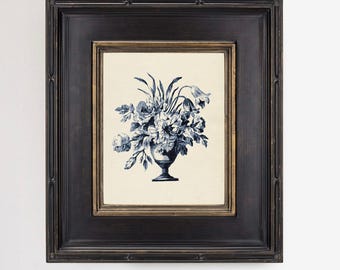 May include: A rectangular black wooden frame with gold inner trim containing a cream-colored print of a blue floral arrangement in a pedestal vase. The text at the bottom reads: *Frames and matting not included.
