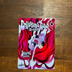 May include: A rectangular trading card featuring vibrant red and pink flowing hair surrounding a central face. The text reads Enlightened Tutor, 悟った教師, Instant, インスタント, and CrusaderCat. The design uses bold, swirling lines and high-contrast colors.