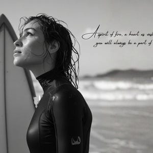 May include: A black and white photograph of a person with wet hair wearing a black wetsuit, standing next to a surfboard. The text reads: A spirit of fire, a heart as vast as the ocean, you will always be a part of our hearts.