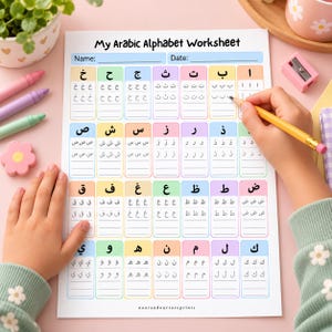 Puede incluir: Una hoja de trabajo de papel blanco titulada My Arabic Alphabet Worksheet con filas de cajas coloridas que contienen letras árabes y líneas de práctica. La hoja presenta columnas para practicar la escritura con un lápiz amarillo.
