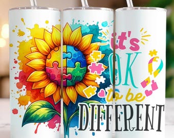 May include: Three white cylindrical tumblers with clear straws. The design features a large sunflower with a colorful puzzle piece center, watercolor splashes, and the text "it's OK to be DIFFERENT" with a puzzle piece ribbon graphic.