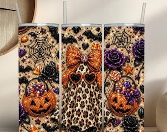 May include: A cylindrical tumbler with a straw featuring a Halloween pattern of orange pumpkins, black bats, spiderwebs, purple roses, candy corn, and a central ghost figure wearing a large orange bow and heart-shaped sunglasses on a glittery background.
