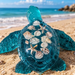 May include: A translucent teal sea turtle figurine featuring a clear shell filled with various small white and brown seashells and a single starfish embedded within the structure, showcasing a smooth, glossy finish and detailed flipper shapes.