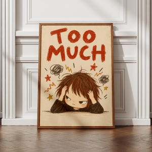 May include: A framed wall art print on a cream background featuring the red text TOO MUCH at the top. Below, a brown-haired character with a dark jumper holds their head, surrounded by hand-drawn black scribbles and yellow and red stars.
