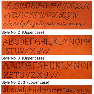 K&ouml;nnte beinhalten: Eine braune Lederoberfl&auml;che mit vier Reihen eingravierter Buchstaben. Stil Nr. 1 zeigt kursive Gro&szlig;- und Kleinbuchstaben. Stil Nr. 2 zeigt Blockbuchstaben in Gro&szlig;schrift. Stil Nr. 3 pr&auml;sentiert Gro&szlig;buchstaben mit Serifen. Eine letzte Zeile zeigt Kleinbuchstaben.