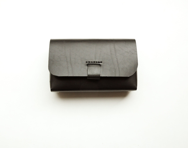 May include: A black leather wallet with a flap closure and a stitched detail.