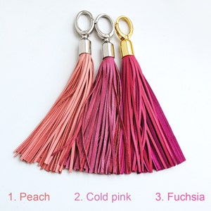 Peut inclure: Trois glands en cuir de couleur pêche, rose pâle et fuchsia avec des anneaux de clés argentés et dorés.