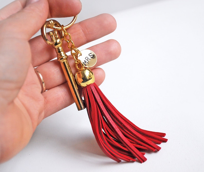 May include: Gold key keychain with a red tassel and a gold charm that says "MRS".