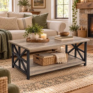 Peut inclure: Une table basse rectangulaire avec un plateau aspect bois vieilli et une étagère inférieure, soutenue par un cadre en métal noir avec des accents latéraux en forme de X. Elle porte un plateau en bois avec une plante et une bougie, et un panier.