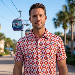 May include: A short-sleeved polo shirt featuring a repeating diamond pattern in red and white, with each diamond containing a small graphic of Donald Duck. The shirt has a classic collar, a buttoned placket, and a standard fit with short sleeves.