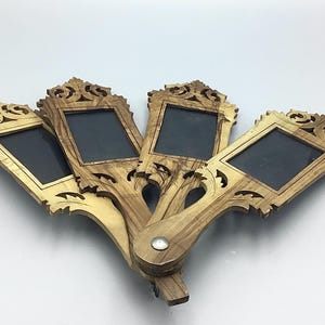 May include: Four decorative hand mirrors with ornate, carved wooden frames. Each mirror has a rectangular viewing area and a long, curved handle. The wood grain varies in color from light to medium brown, with decorative flourishes at the top.