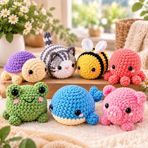 May include: A collection of seven crocheted stuffed animals including a purple and cream turtle, a gray striped cat, a yellow and black bee, a pink octopus, a green frog, a blue whale, and a pink pig, all featuring black safety eyes.