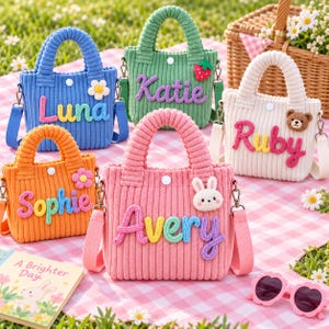 May include: Five small corduroy handbags in blue, green, white, orange, and pink. Each bag features a name in colorful yarn letters: Luna, Katie, Ruby, Sophie, and Avery. Decorative patches include a flower, strawberry, bear, and rabbit.