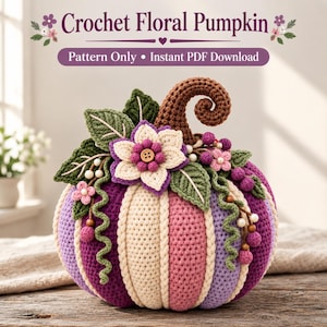May include: A crochet pumpkin featuring vertical stripes in shades of purple, pink, and cream. The top is adorned with a brown curly stem, green leaves, a central cream and purple flower with a brown button center, and small berry accents.