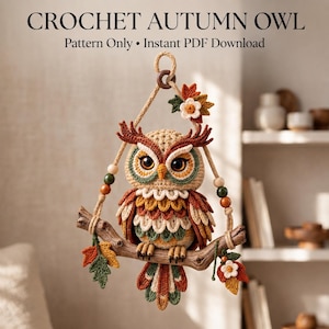 Könnte beinhalten: Ein gehäkelter Eulen-Wandbehang mit dem Text CROCHET AUTUMN OWL Pattern Only Instant PDF Download. Die Eule hat braune, orangefarbene und grüne Federn, große Augen und sitzt auf einem Ast mit hängenden Blättern und Holzperlen.