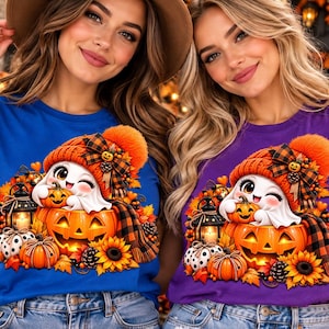 Peut inclure: Un t-shirt bleu et un t-shirt violet, chacun arborant un motif de fantôme faisant un clin d'œil avec un bonnet orange, assis dans une citrouille sculptée entourée de feuilles d'automne, de tournesols et d'une lanterne.