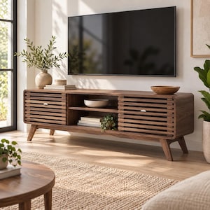 May include: A long, rectangular dark wood media console featuring two slatted sliding doors on the ends and an open central shelving unit. The console stands on four angled legs and holds a flat-screen television mounted on the wall above it.