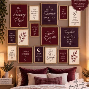 May include: A collection of 16 wall art prints featuring burgundy and cream color schemes with motivational text and botanical illustrations. The prints are displayed in various sizes within light wood frames on a wall above a bed.