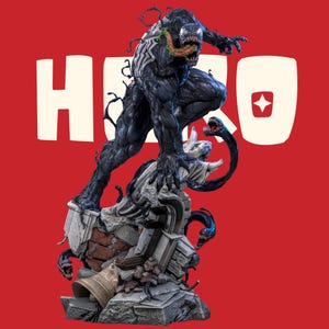 May include: A detailed Venom figurine in a dynamic pose, featuring a black muscular body, white spider emblem, and a long green tongue. The character stands on a base of gray stone rubble and debris, with smaller black tendrils emerging from the base.