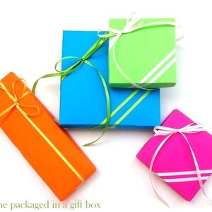 May include: Four gift boxes wrapped in different colors: orange, blue, green, and pink. Each box is tied with a ribbon and bow.