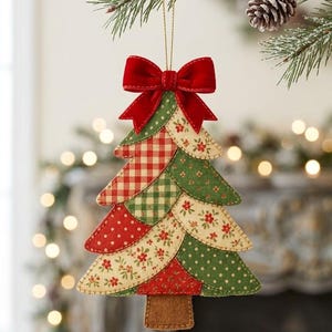 Puede incluir: Un adorno navideño de tela con forma de árbol, compuesto por paneles superpuestos en tonos rojos y verdes con estampados de cuadros vichy, lunares y flores. El adorno está rematado con un lazo de terciopelo rojo y cuelga de un hilo dorado.