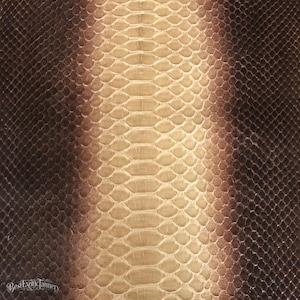 Puede incluir: Una hoja texturizada de piel de serpiente con un patrón degradado que transita de marrón oscuro en los bordes exteriores a un color crema y beige más claro en el centro. El texto BestExoticTannery está impreso en la esquina inferior izquierda.