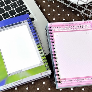 May include: Two spiral-bound notebooks featuring computer interface designs. The left notebook displays a blue and green desktop background with an Untitled-Notepad window. The right notebook shows a pink Microsoft Word document interface.