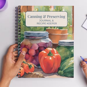 May include: A spiral-bound journal titled "Canning & Preserving Journal & Recipe Keeper." The cover features a watercolor illustration of canning jars filled with produce, including tomatoes and a red bell pepper. The background shows a garden scene.