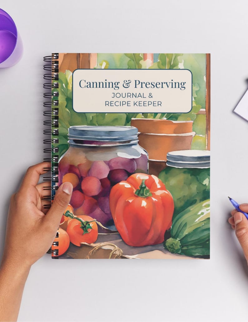 May include: A spiral-bound journal titled "Canning & Preserving Journal & Recipe Keeper." The cover features a watercolor illustration of canning jars filled with produce, including tomatoes and a red bell pepper. The background shows a garden scene.