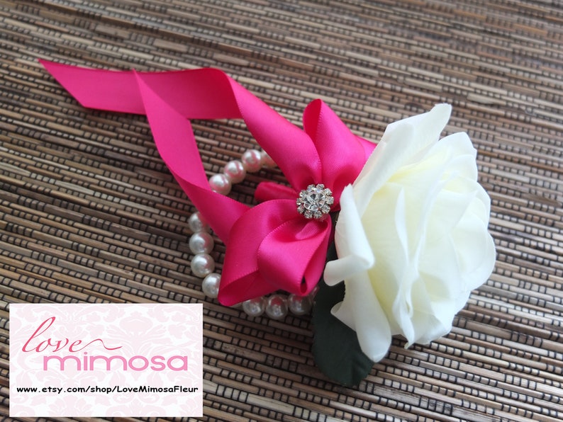 Wrist Corsage Ivory Rose with fuchsia ribbon on pearl bracelet