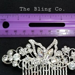May include: Silver hair comb with a butterfly design and rhinestones. The comb is 2 inches long.