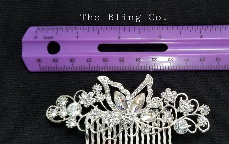 May include: Silver hair comb with a butterfly design and rhinestones. The comb is 2 inches long.