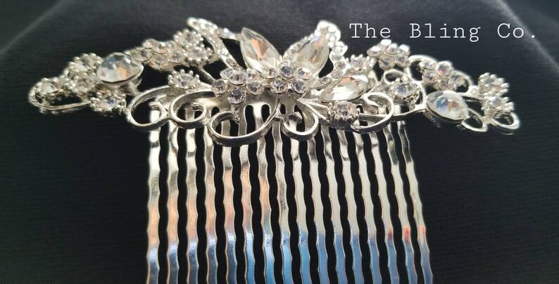 May include: Silver hair comb with a decorative design of a butterfly with clear rhinestones. The comb has a silver finish and is adorned with sparkling crystals.
